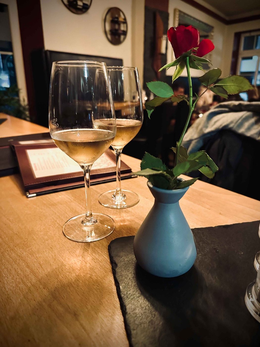 Gedeckter Tisch mit Weinglas und Rose